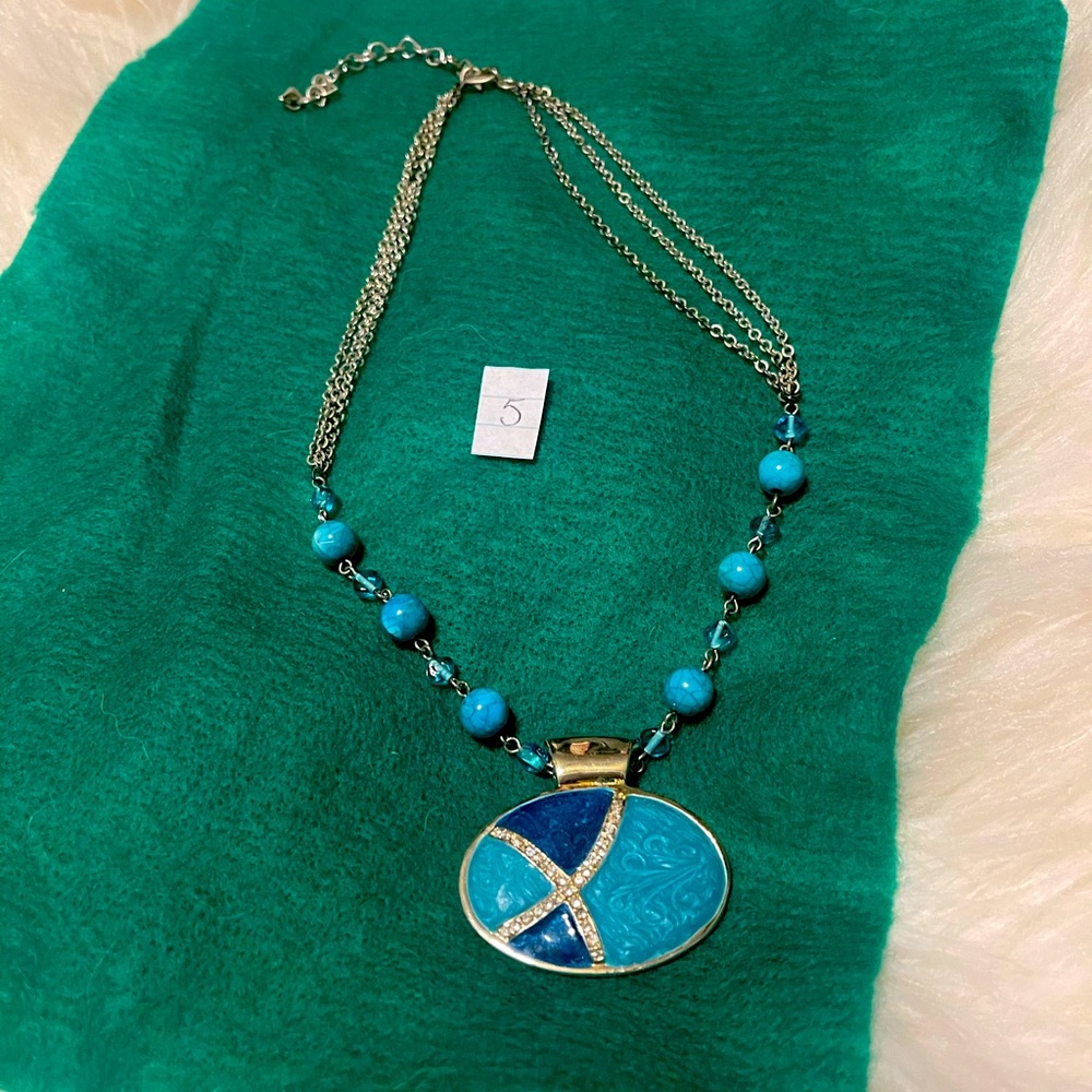 Turquoise with diamonds pendant on a silver chain.